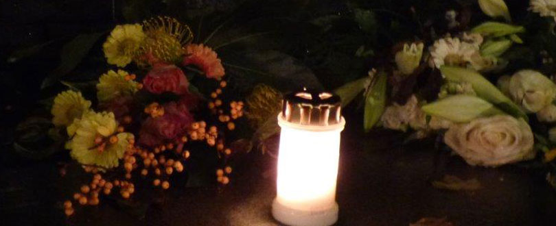 Kaarsje bij bloemen tijdens herinneringsweken