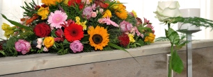 Houten kist met kleurrijk bloemstuk in opbaarkamer