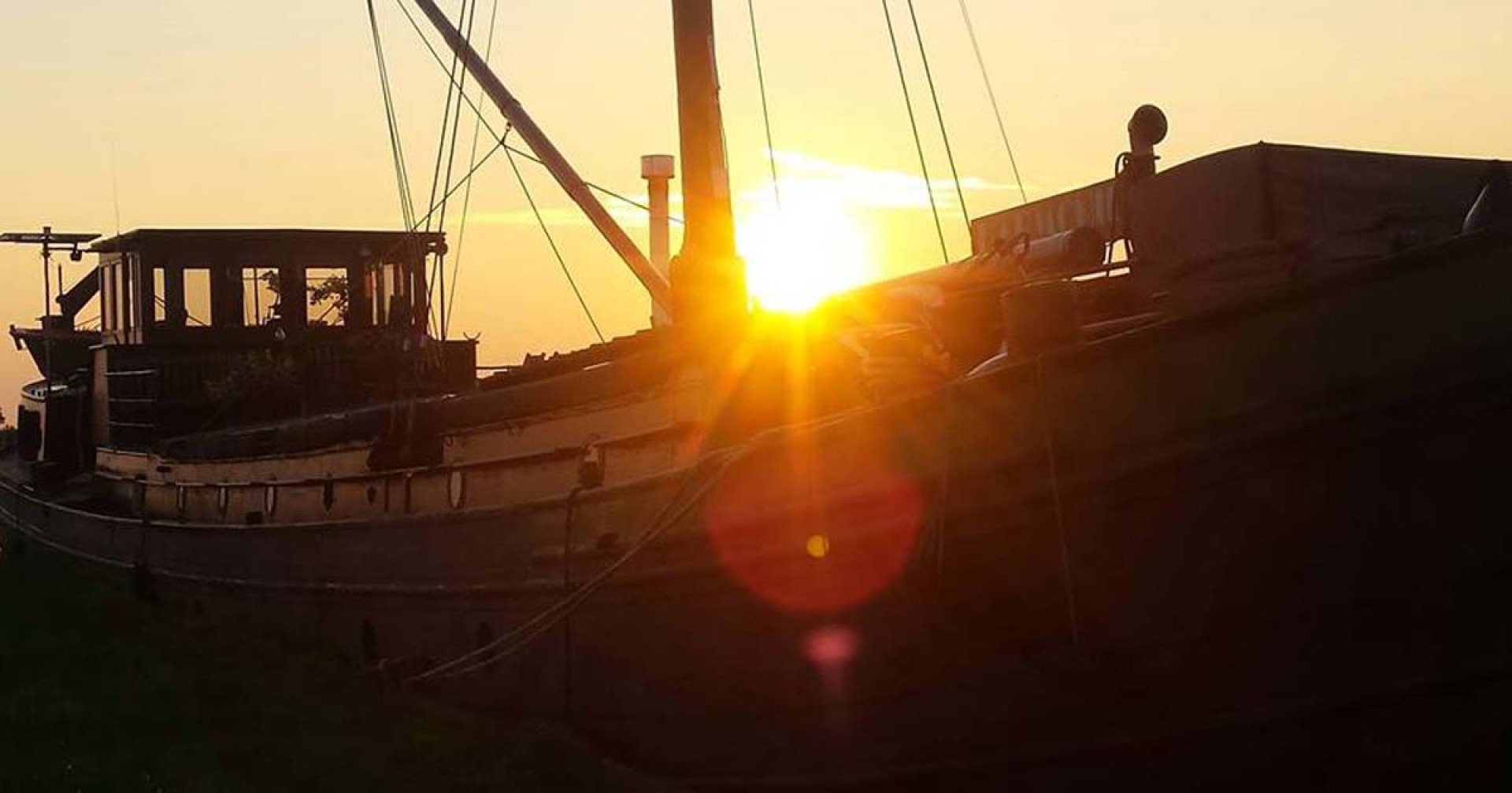 Ondergaande zon boven klassiek woonschip