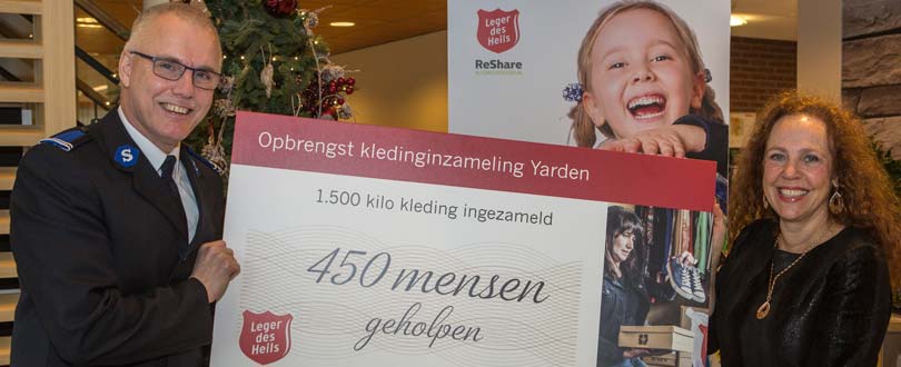 Simon Smedinga (operationeel directeur bij het Leger des Heils) krijgt de check met hoeveel kleren er opgehaald zijn overhandigd door Sabrina Franken (directeur Uitvaartverzorging bij Yarden)